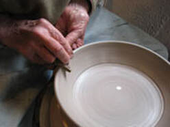 Pam Parziale puts the finishing touches on a Sycamore Pottery bowl